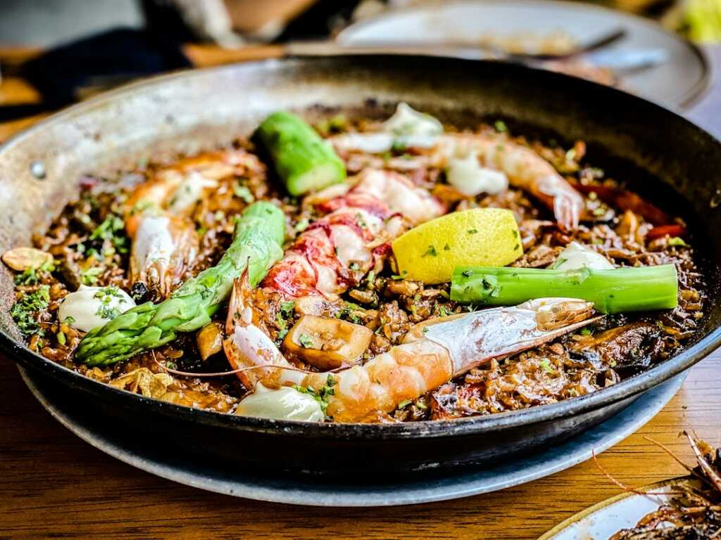 Arroz con bogavante meloso: receta marinera paso a paso 2 Arroz con bogavante cocinándose en una paellera
