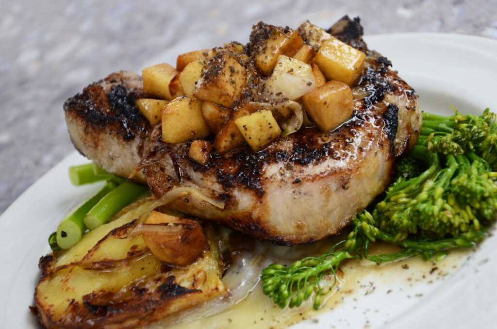 Chuletas de cerdo doradas antes de terminar la receta con manzana y sidra